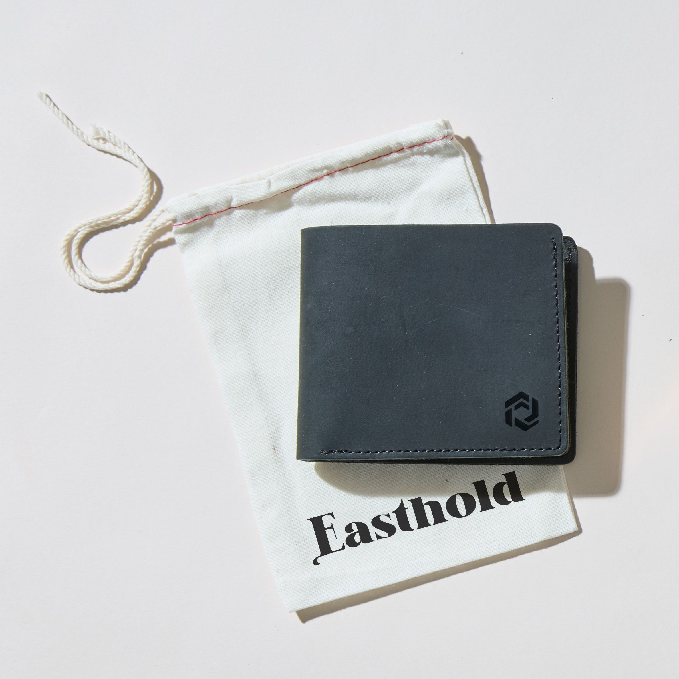Black leather wallet with logo engraving branding on a white surface