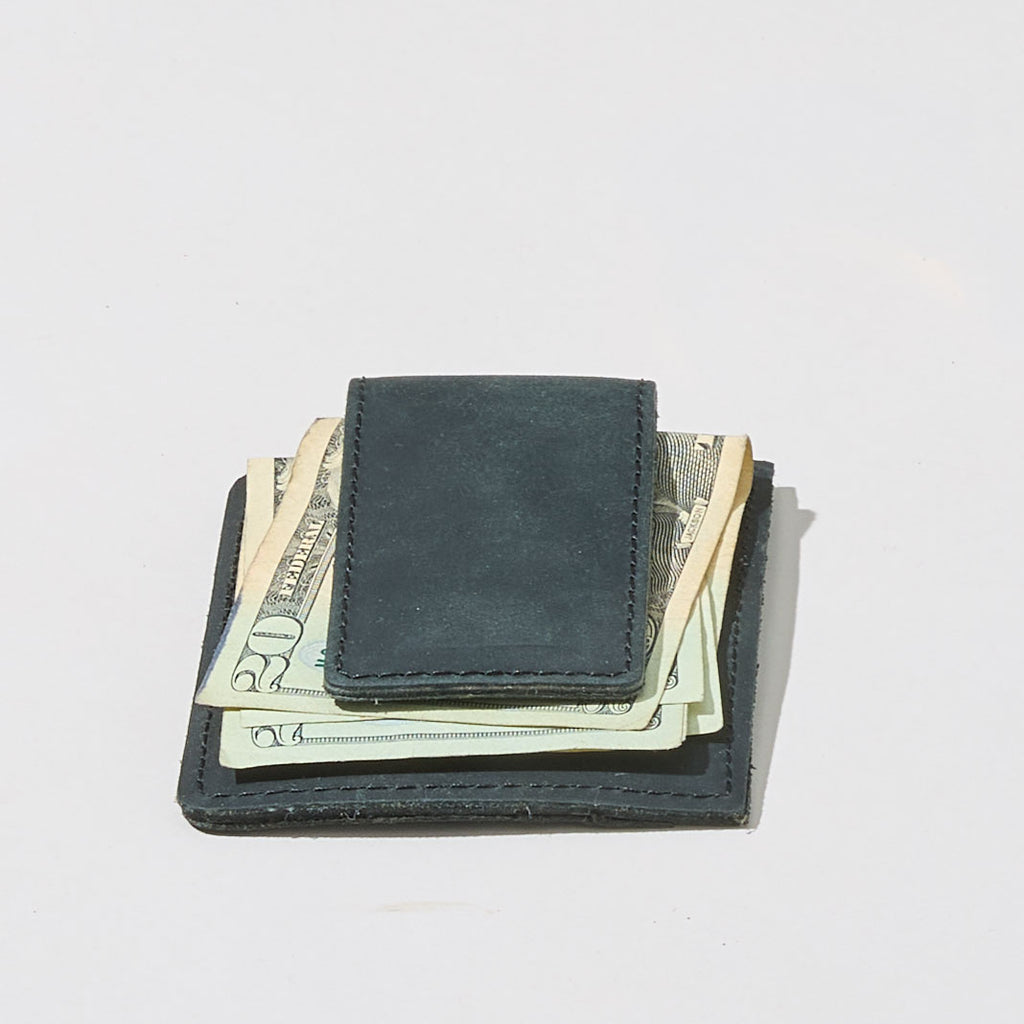 Black wallet with money sticking out on a light gray background