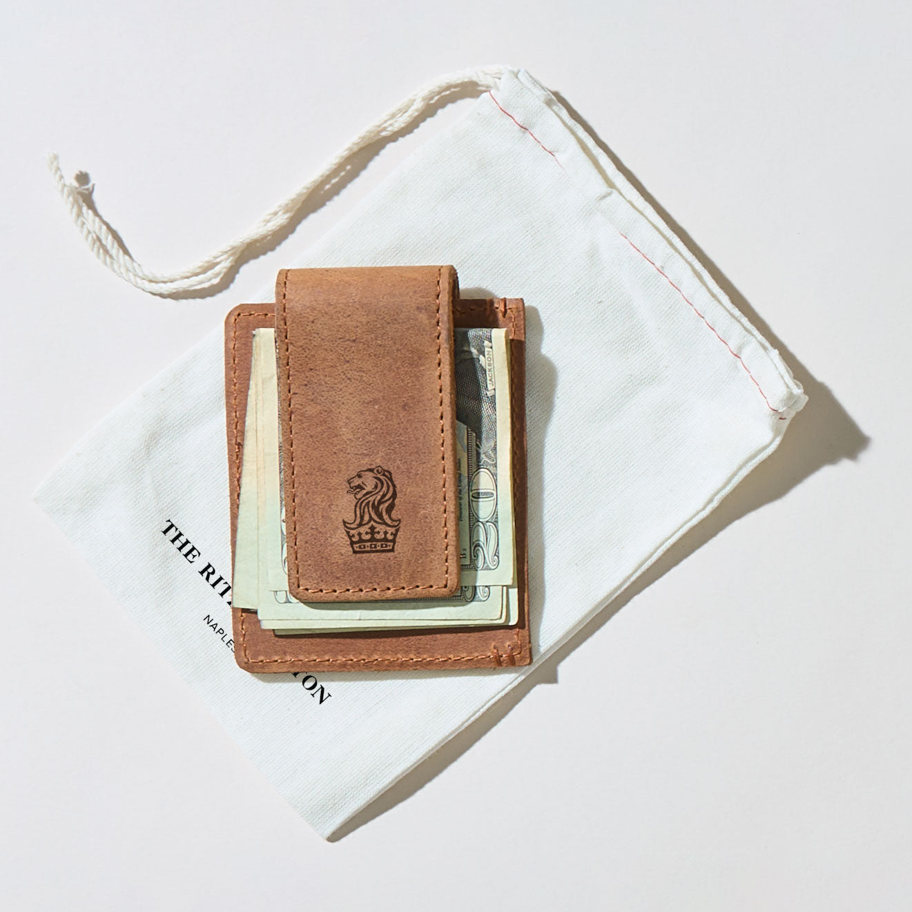 Brown leather wallet with money sticking out on a white background