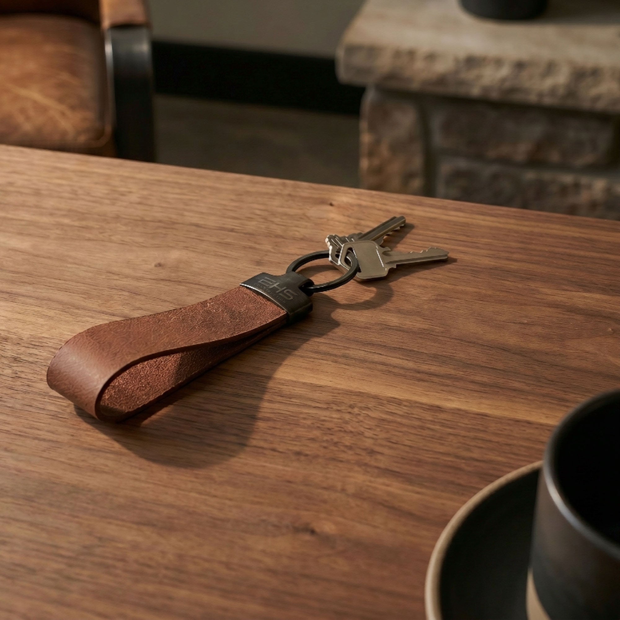 Brown leather keychain with keys on a wooden table
